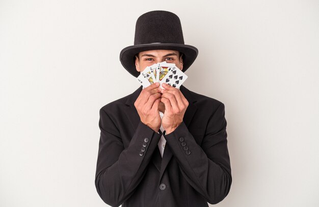 Foto jovem mago homem caucasiano segurando cartas mágicas isoladas no fundo branco