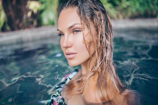 Jovem magro sensual relaxante na piscina