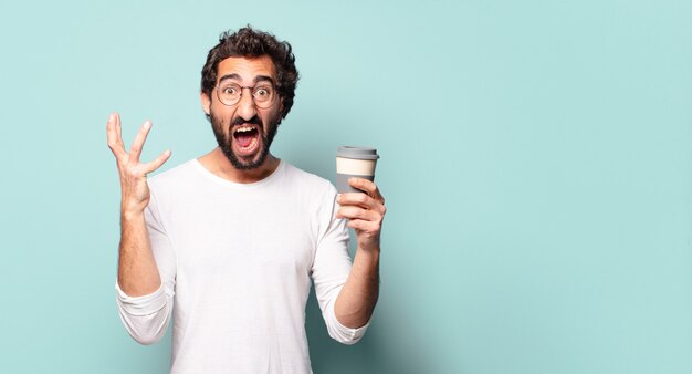 Jovem maluco de barba com um café para viagem