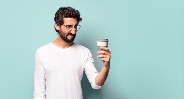 Jovem maluco de barba com um café para viagem