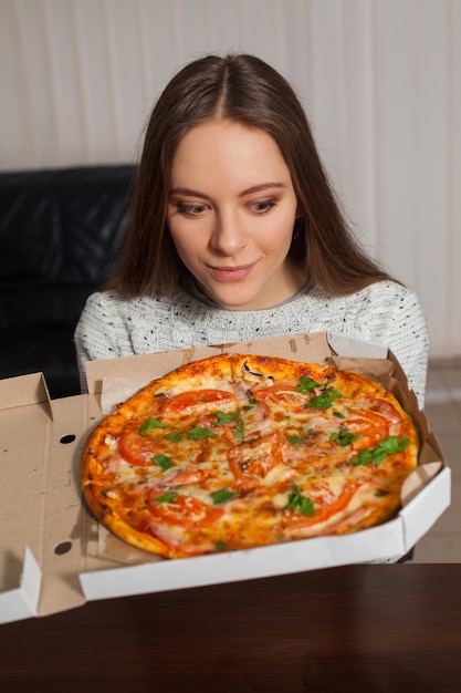 Jovem mantém deliciosa pizza nas mãos