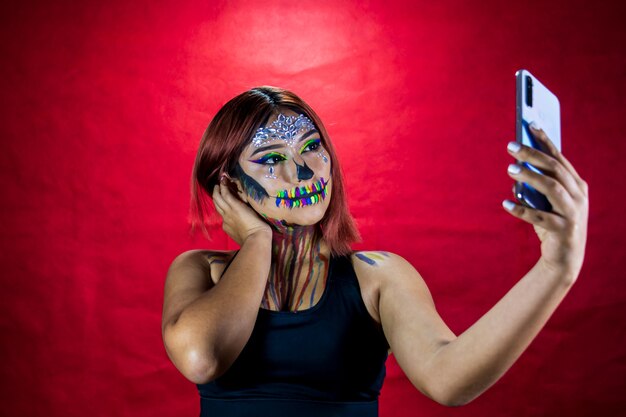 Jovem maquiada para a festa de halloween tira uma selfie do celular