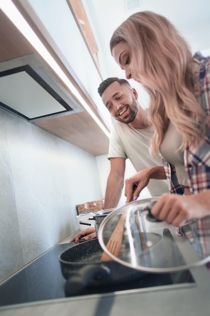 Jovem marido e mulher cozinham o jantar juntos