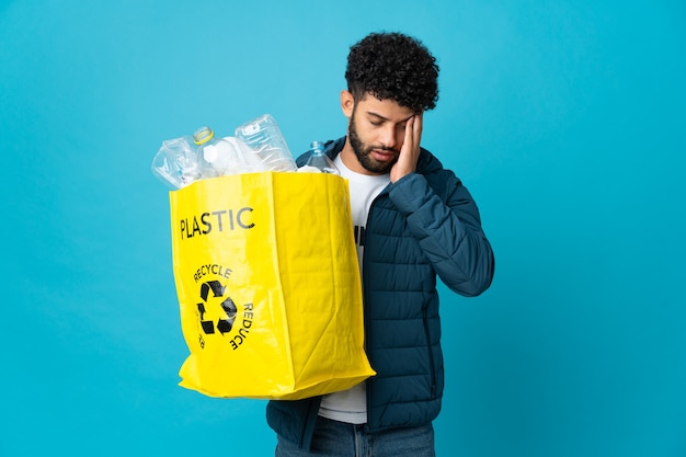 Jovem marroquino segurando um saco cheio de garrafas de plástico para reciclar isolado