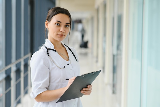 Jovem médica feliz usa estetoscópio de casaco médico branco uniforme Retrato de uma linda médica terapeuta enfermeira