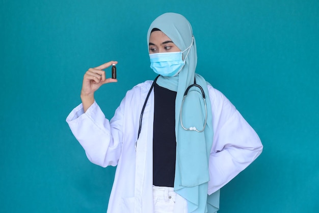 Jovem médica hijab segura frasco de remédio para injeção. Frasco de vidro médico para vacinação.