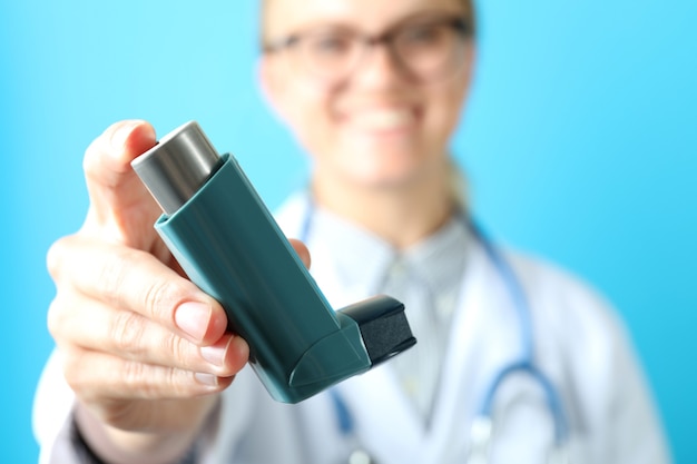 Jovem médica segurando inalador para asma, close-up e foco seletivo