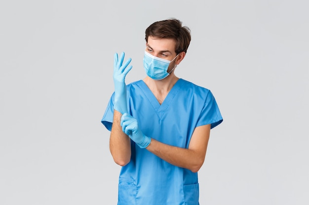 Jovem médico bonitão de uniforme azul