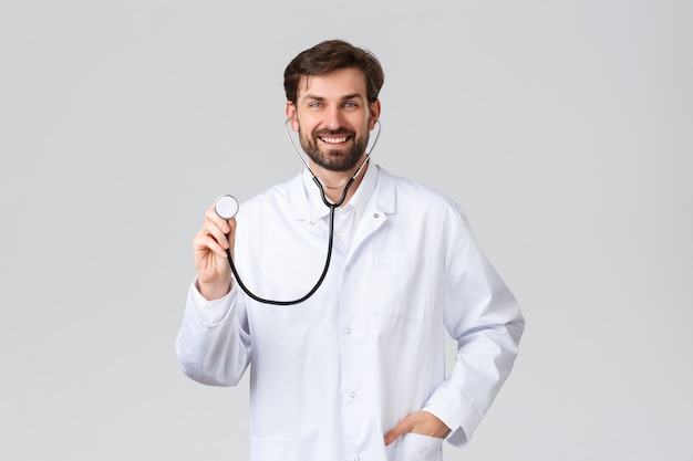 Jovem médico bonitão de uniforme branco