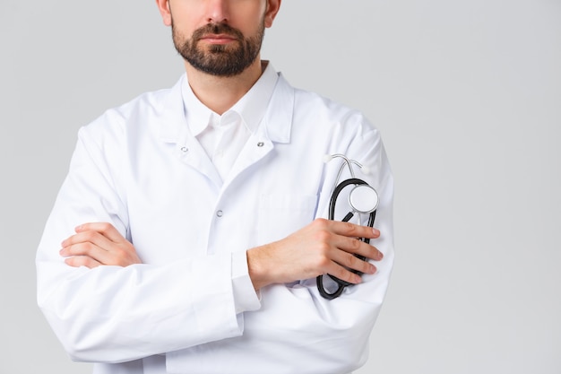 Jovem médico bonitão em um uniforme branco