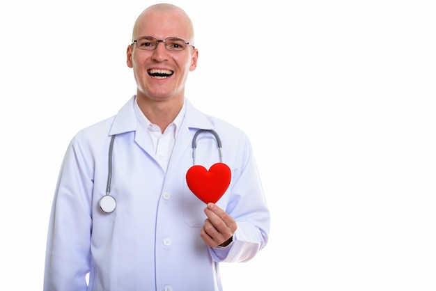 jovem médico careca feliz sorrindo enquanto segura o coração