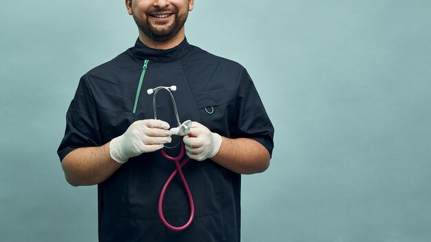 Jovem médico com roupa profissional e um estetoscópio sobre um fundo azul claro