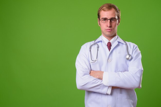 Jovem médico contra parede verde