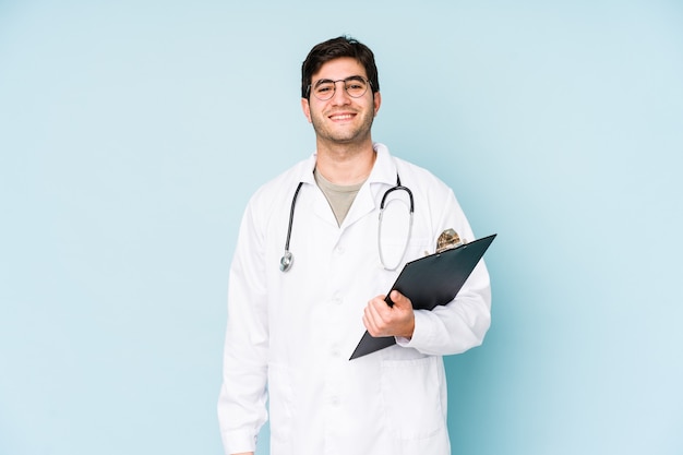 Jovem médico em azul feliz, sorridente e alegre.