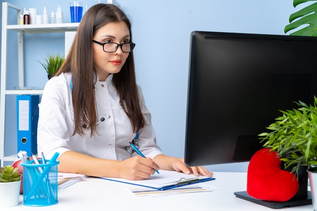 Foto jovem médico feminino legal trabalhando em seu escritório