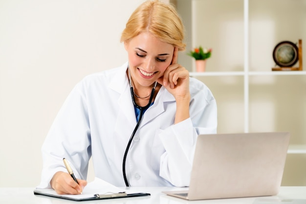 Jovem médico feminino trabalhando no escritório do hospital. Conceito médico e de saúde.