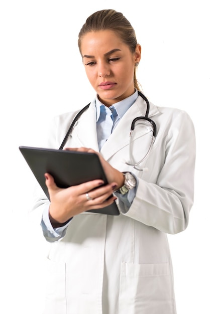 Jovem médico feminino usando tablet digital contra parede branca