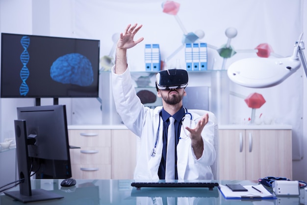 Jovem médico masculino realizando procedimento médico usando fone de ouvido de realidade virtual. nova tecnologia na medicina