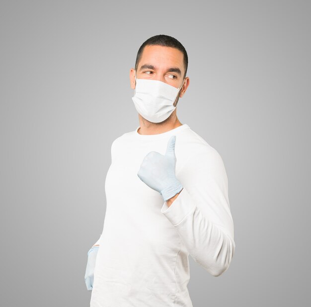 Jovem médico masculino usando máscara e luvas de proteção