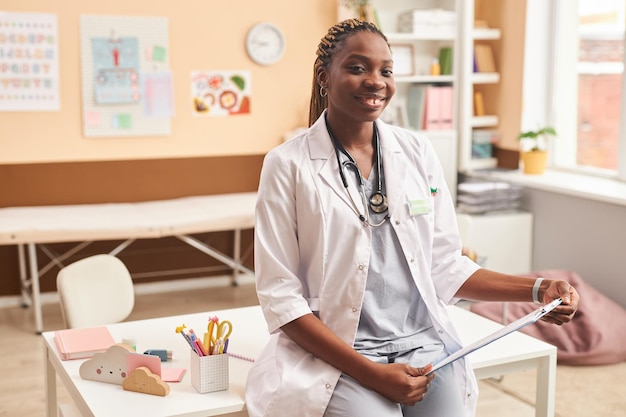 Jovem médico negro como médica na câmera em uma clínica para crianças