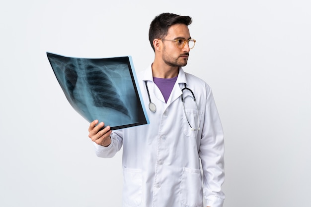 Jovem médico segurando uma radiografia isolada no lado branco