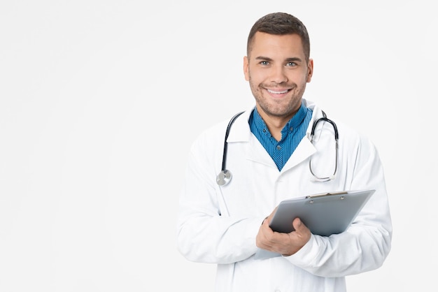 Jovem médico sorrindo com estetoscópio e segurando a prancheta no fundo de cor branca