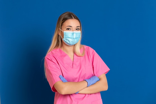 Jovem médico vestindo um rosto de máscara e um uniforme rosa