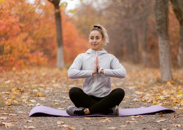 Jovem meditando na floresta de outono