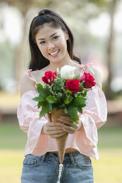 jovem menina asiática com rosas vermelhas sorrindo hoppy no dia dos namorados