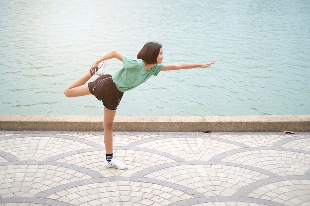 Jovem menina asiática exercício no parque de saúde.