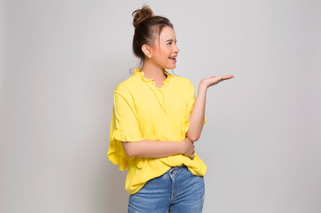 Foto jovem menina asiática segurando algo com a mão