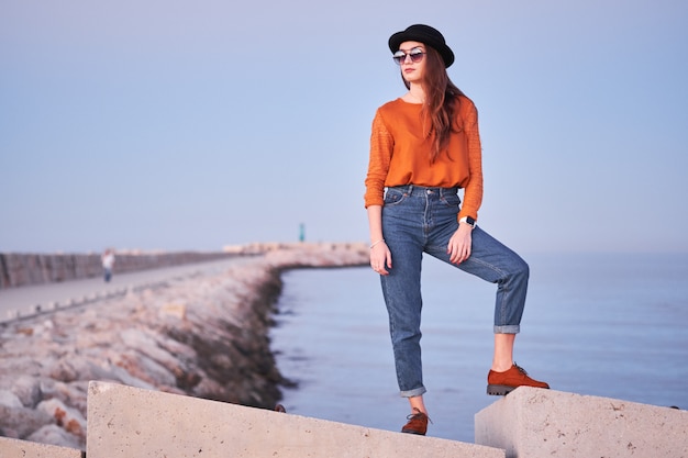 Jovem menina elegante posando em um porto marítimo