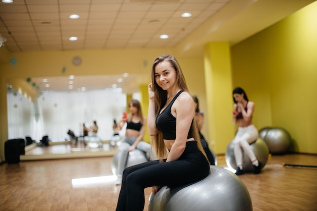 Foto jovem menina linda posando após sessões de grupo no ginásio.