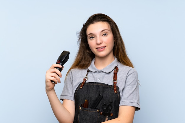 Jovem menina morena com cabeleireiro ou barbeiro e segurando a máquina de corte de cabelo