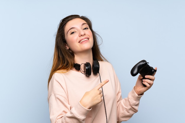 Jovem menina morena isolada parede azul jogando em videogame