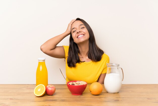 Jovem menina morena tomando café da manhã leite rindo