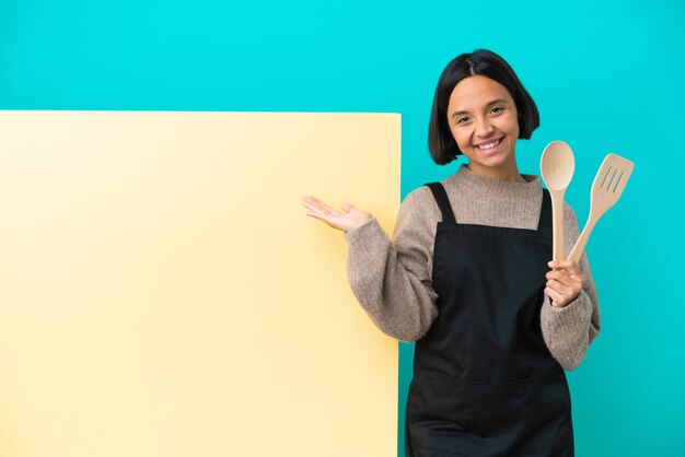 Jovem mestiça cozinheira com um grande cartaz isolado