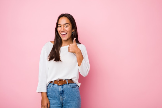 Jovem mestiça indiana sorrindo e levantando o polegar