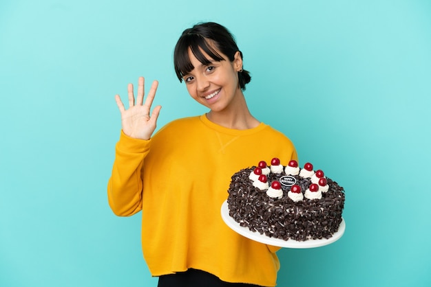 Jovem mestiça segurando bolo de aniversário e contando cinco com os dedos