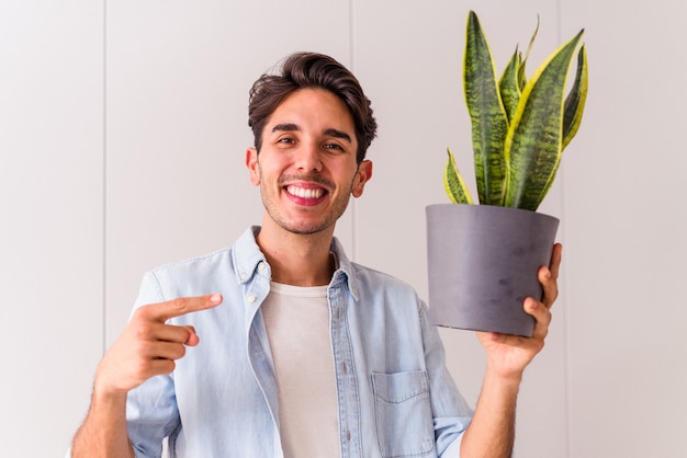 Jovem mestiço com uma planta na cozinha