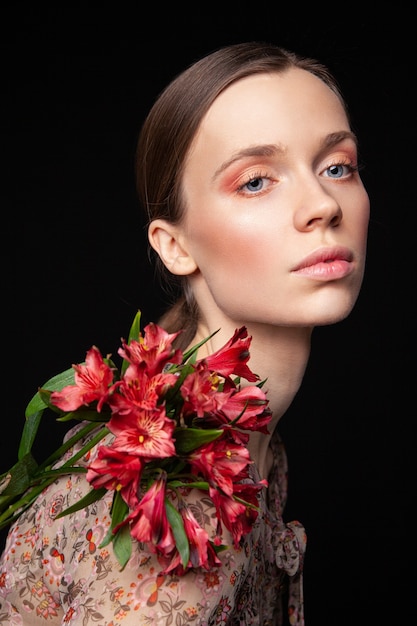 Jovem modelo feminino elegante com flores delicadas