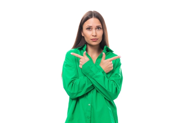 Jovem modelo feminino europeu com cabelo preto bem cuidado e maquiagem vestida com uma camisa verde cruzada