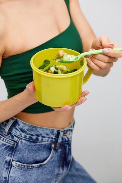 Jovem modelo mulher saudável comendo vegetais verdes abacate pepino e ervas verdes Desintoxicação vegetariana alimentação saudável e conceito de dieta