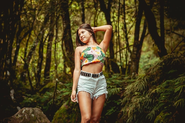 Jovem modelo na floresta em roupas da moda