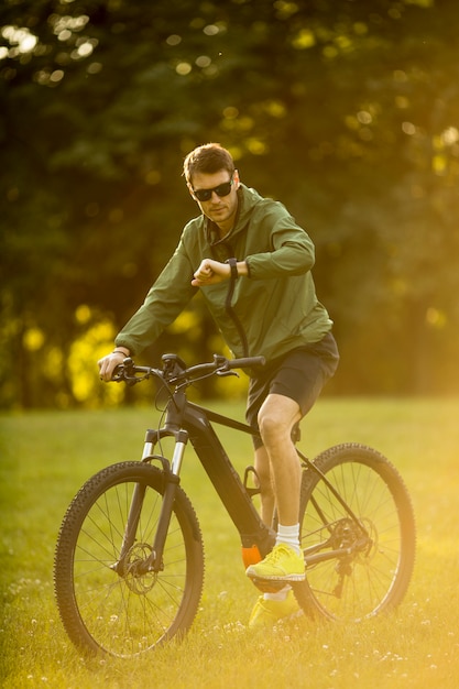 Jovem, montando ebike na natureza