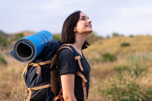 Jovem montanhista com uma grande mochila ao ar livre