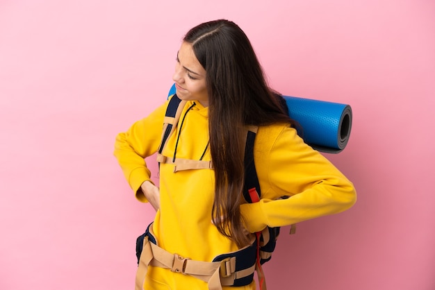 Foto jovem montanhista com uma grande mochila isolada sofrendo de dor nas costas por ter feito esforço