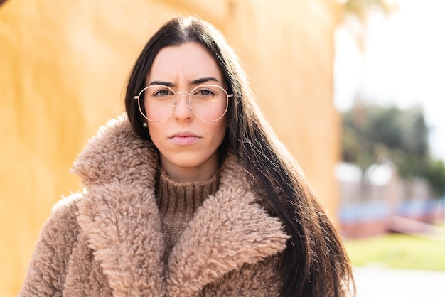 Jovem morena ao ar livre com óculos