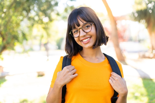 Jovem morena ao ar livre com uma expressão feliz