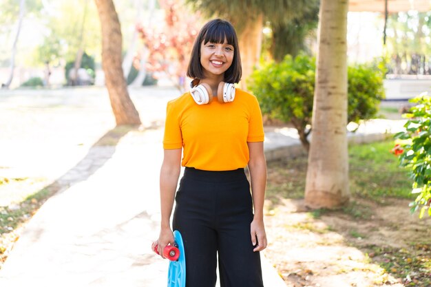 Jovem morena ao ar livre com uma expressão feliz